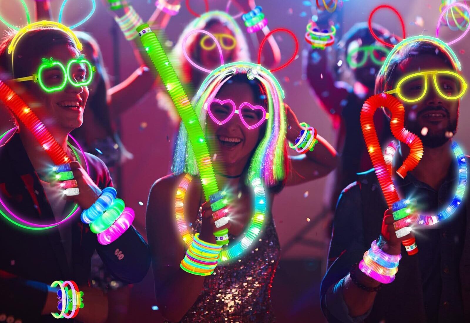 Partygoers enjoying a vibrant neon glow party with glowing accessories and confetti in the air.