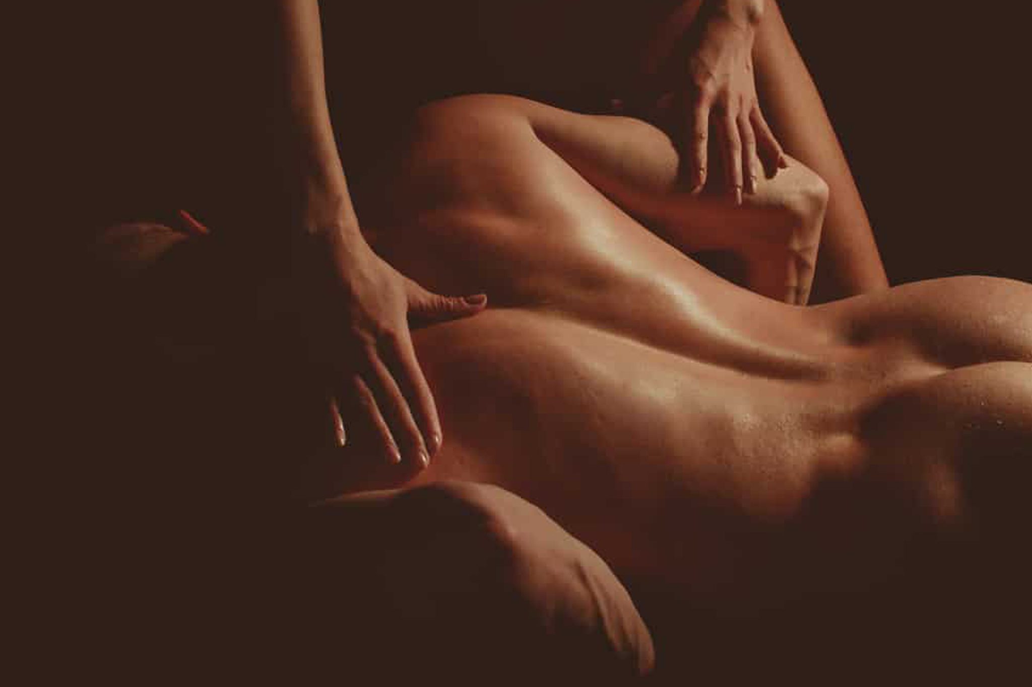 Person receiving a relaxing full-body massage with dim lighting, emphasizing wellness and relaxation.