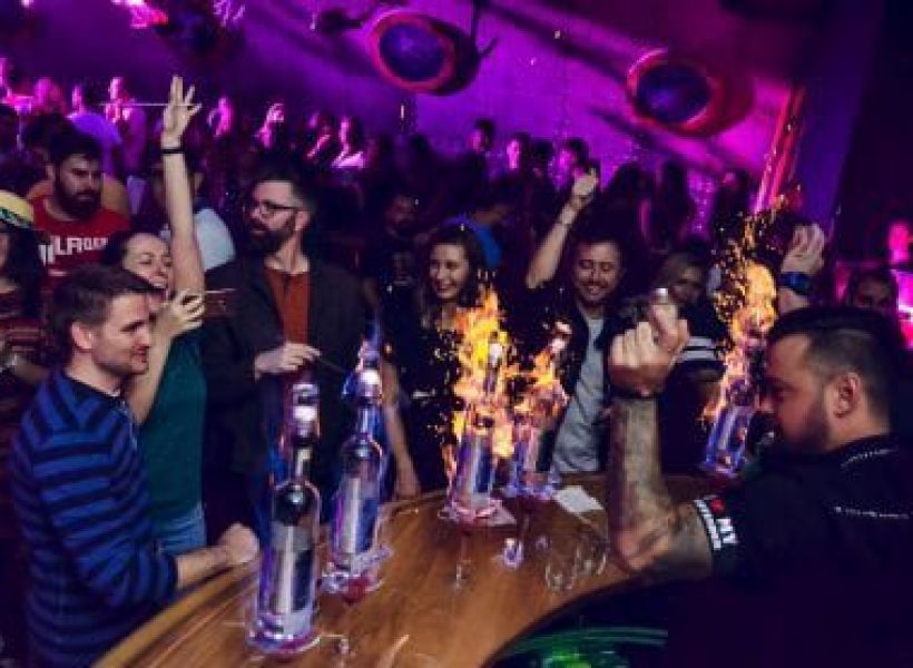 pub-crawl-bucharest Group enjoying a vibrant nightclub with sparklers and drinks on a lively night out.