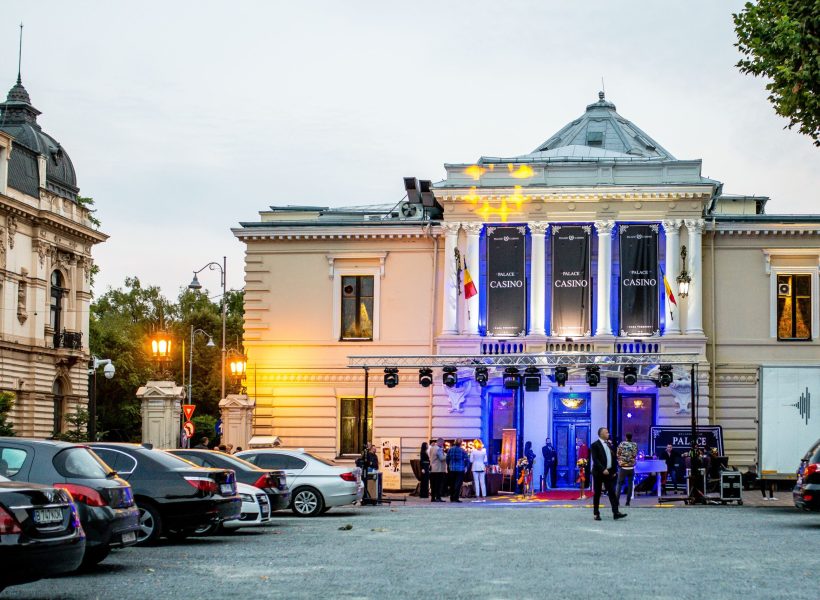 Palace Casino4 Elegant exterior of a grand casino building with parked cars and warm evening lights.