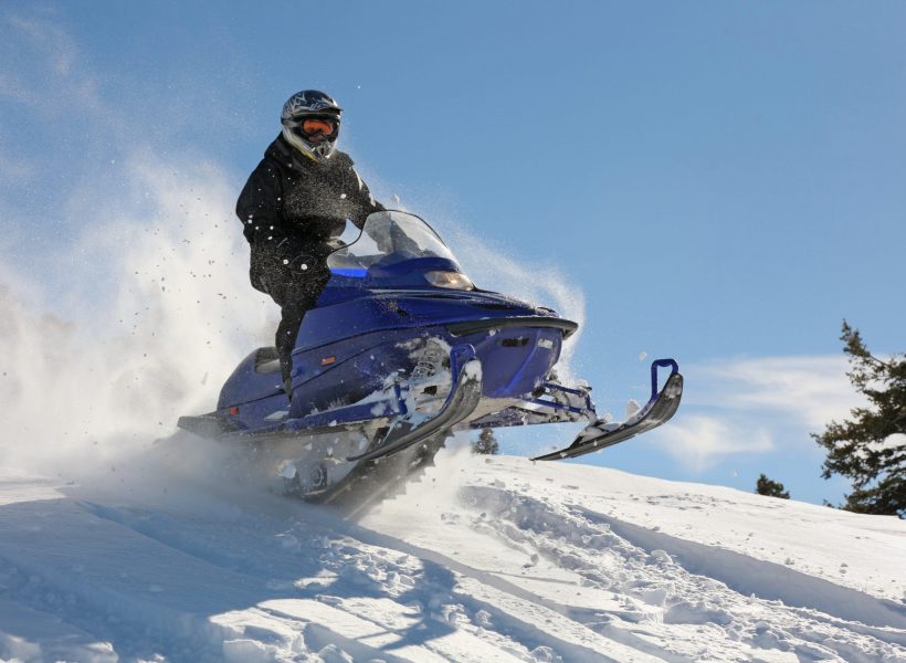 man speeding on a snowmobile