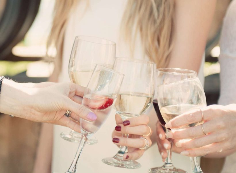 Welcome Host & Champagne at Accommodation 3 People toasting with wine glasses at a celebration gathering outdoors.