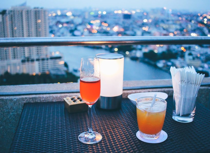 Cocktail glasses with candle light in rooftop bar against city view