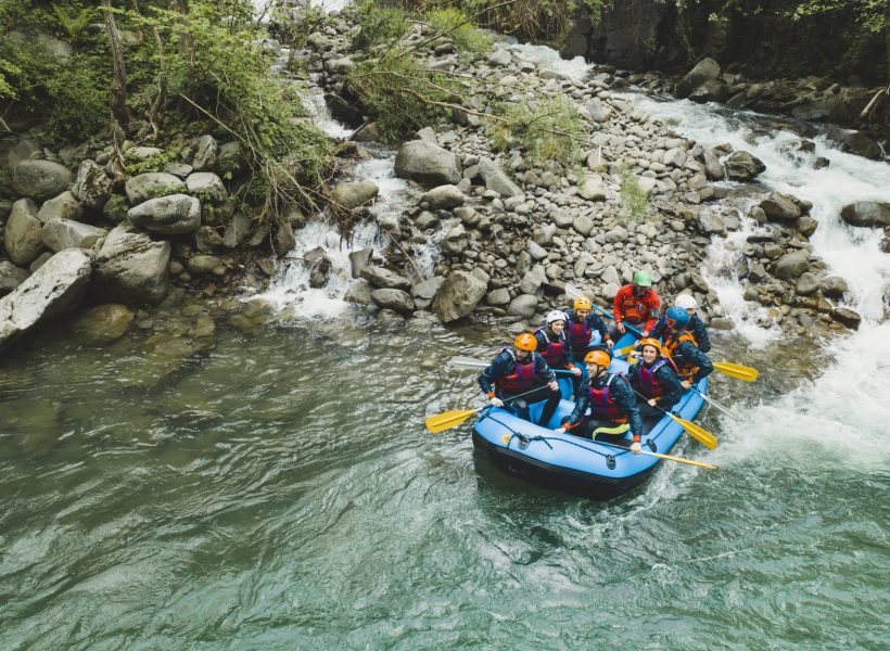 Group of people rafting in rubber dinghy on a river