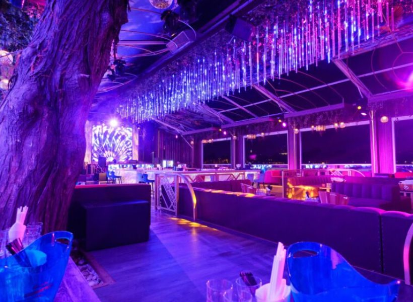 kayo6-840×0-1 Vibrant nightclub interior with colorful lighting, modern seating, and a lively atmosphere.