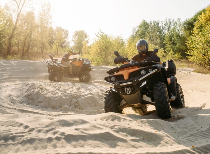 two-atv-riders-in-helmets-ride-in-a-circle-on-sand-1-e1645644912223.jpg