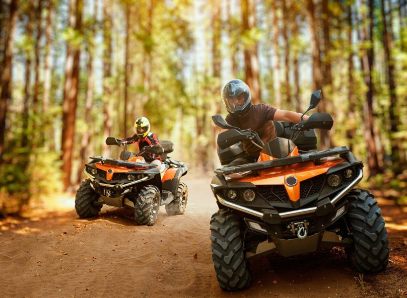 two-atv-riders-speed-race-in-forest-front-view-e1644352663869.jpg